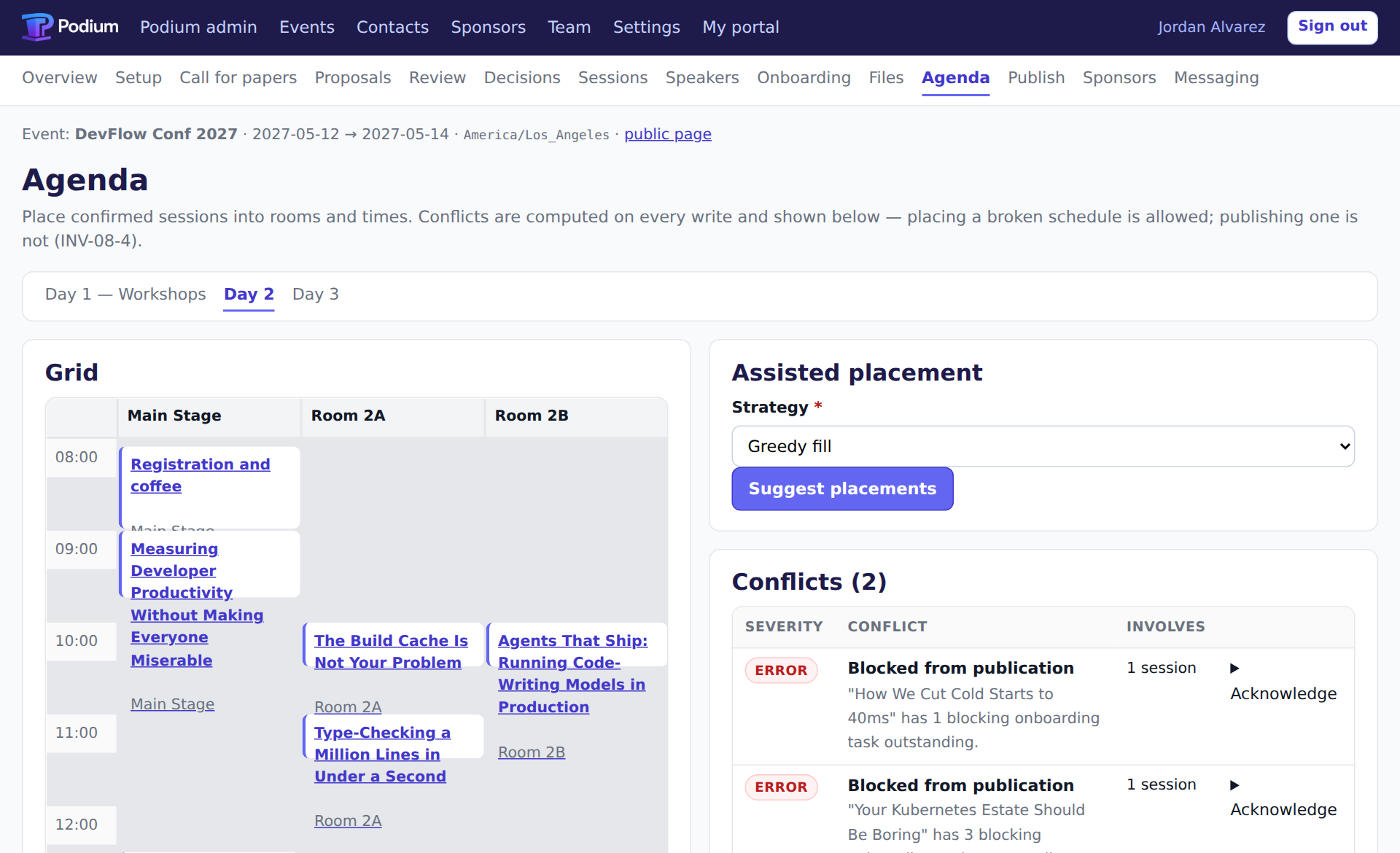 The agenda screen: a room-by-time grid with sessions placed across Main Stage, Room 2A and Room 2B, beside a panel listing two conflicts that block publication.